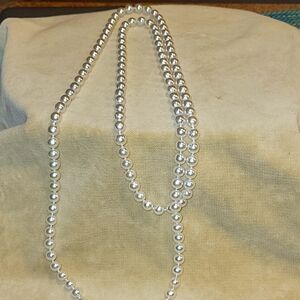 Faux long strand pearls: Pure white.